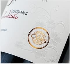 Wine label with gold foil seal and subtle embossed vine motif on textured stock